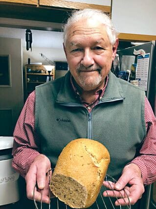 Author L. Weiss holds loaf with smile on his face