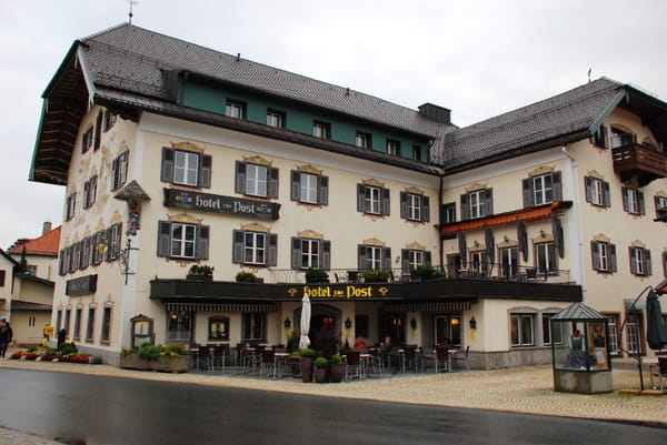 Hotel Post in Mittenwald, Bavaria. Imposing older building, three stories high, wooden shutters on all windows.